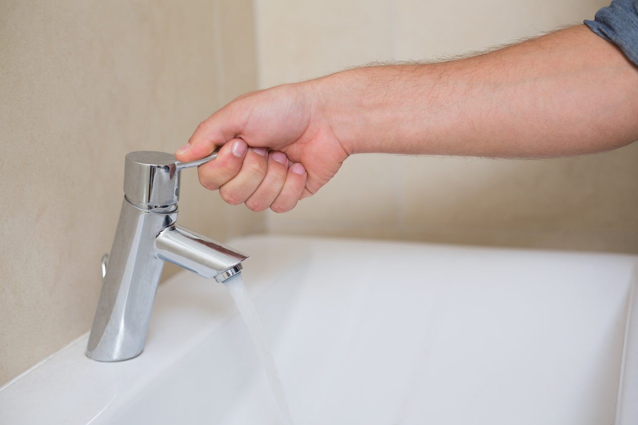 hand turning on faucet