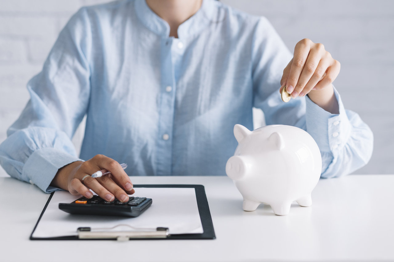 woman putting coin in piggy bank