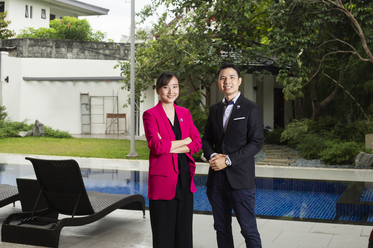 man and woman real estate brokers in front of swimming pool