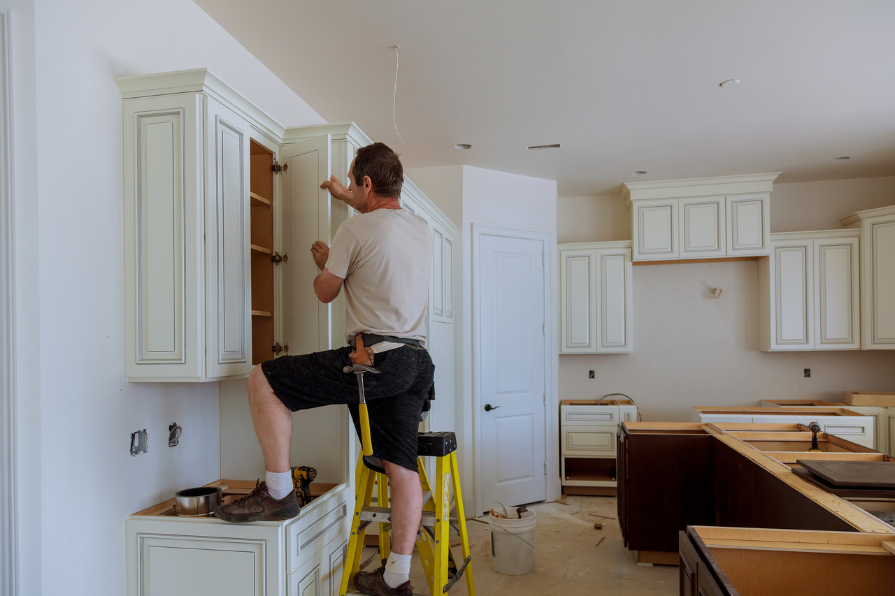 man replacing kitchen cabinets