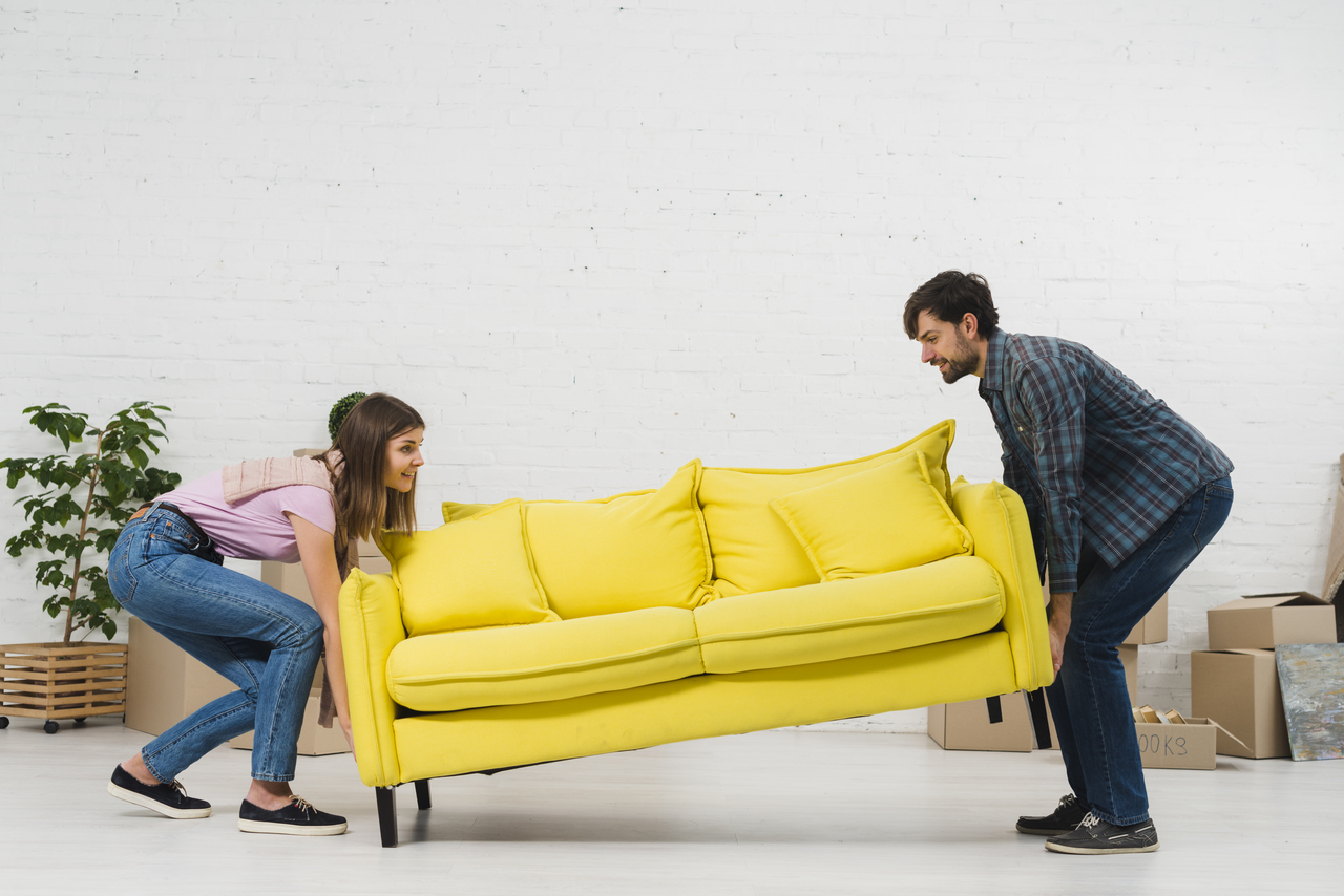 man and woman moving yellow couch