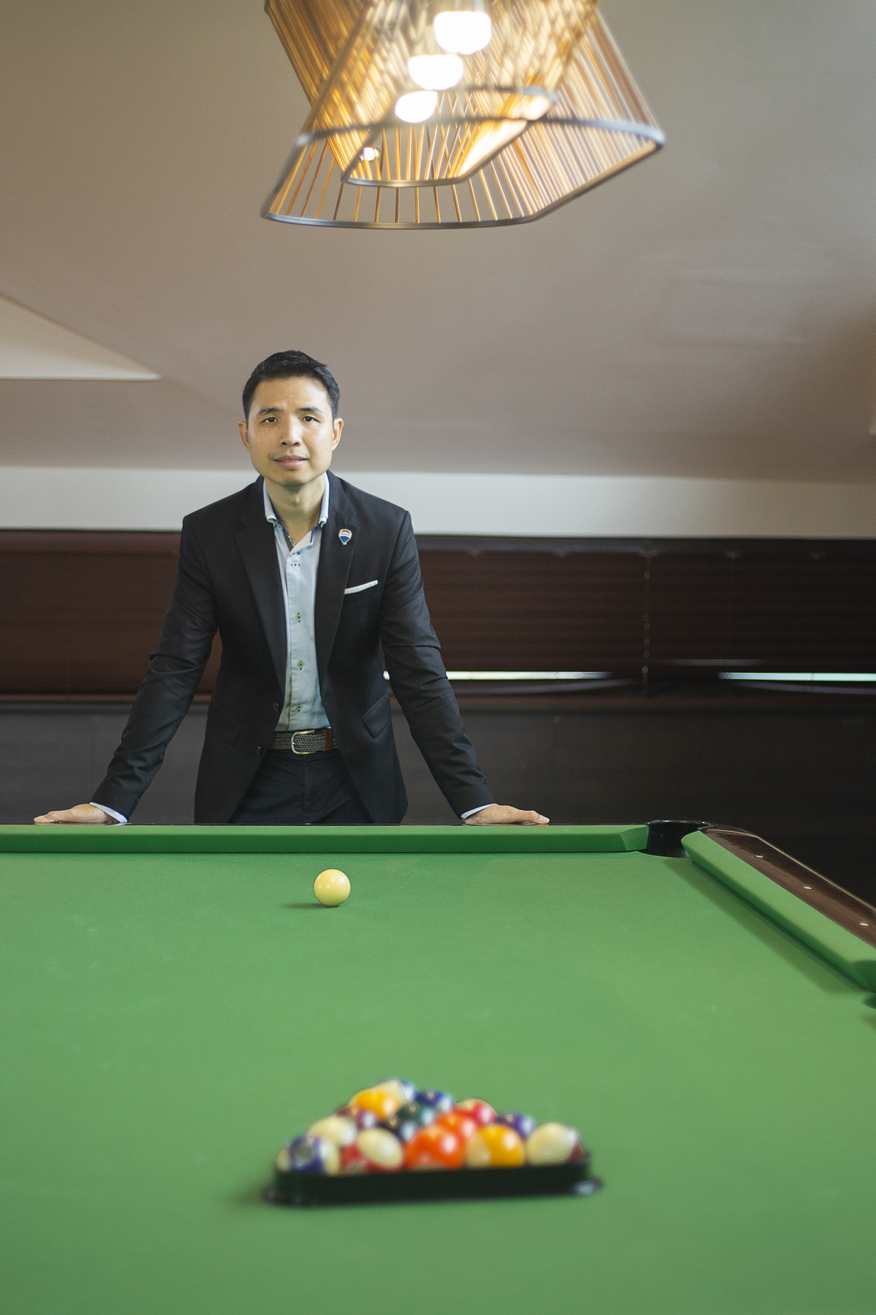 John Yu leaning over a billiards table