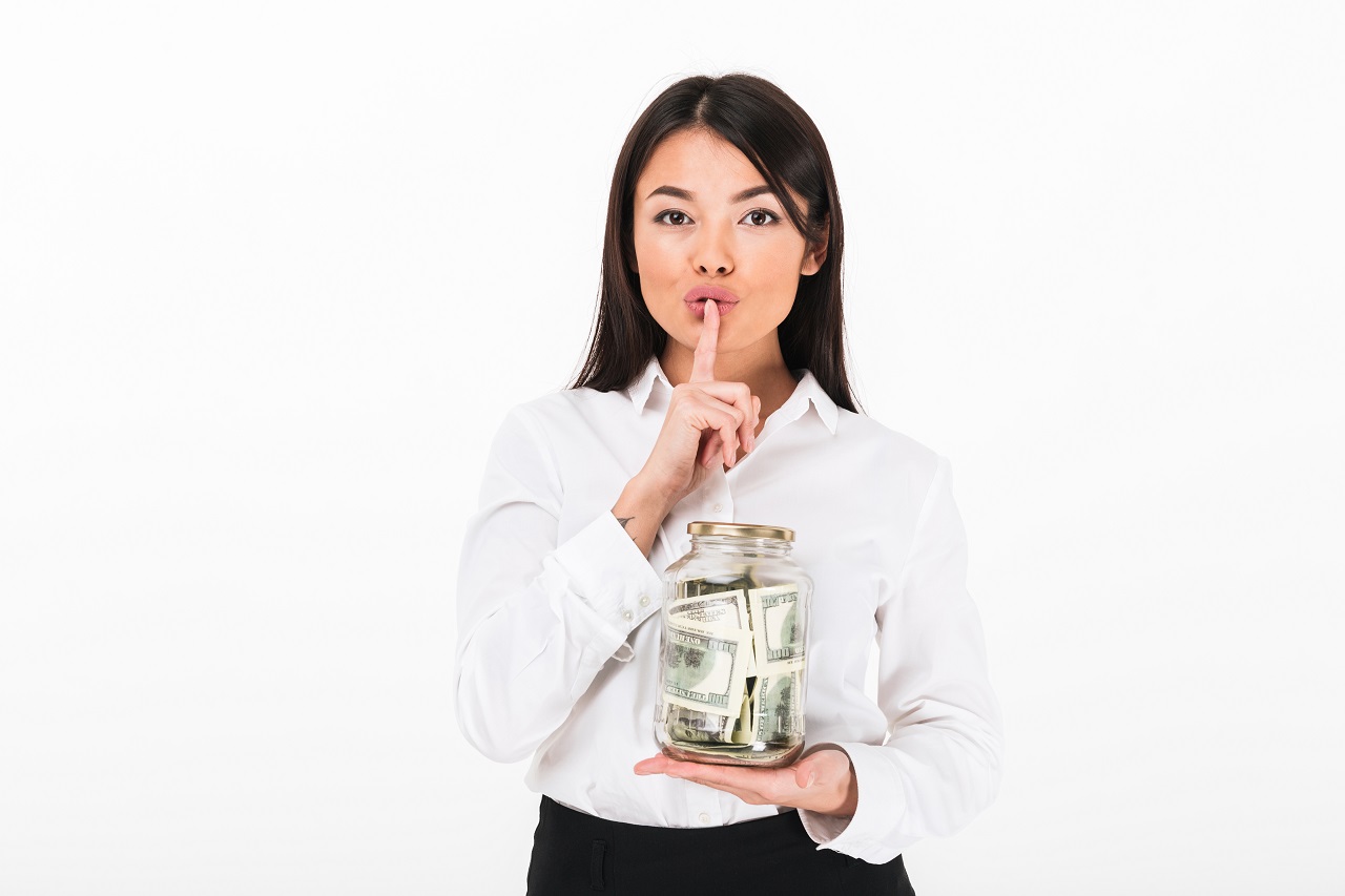 businesswoman holding jar full of money