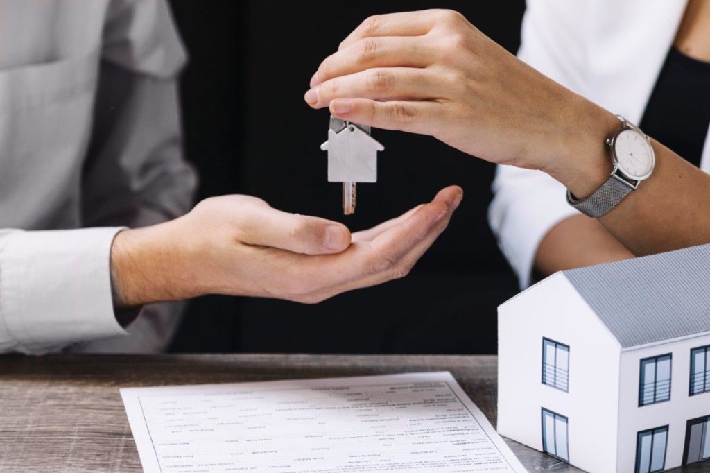 real estate broker handing keys to house