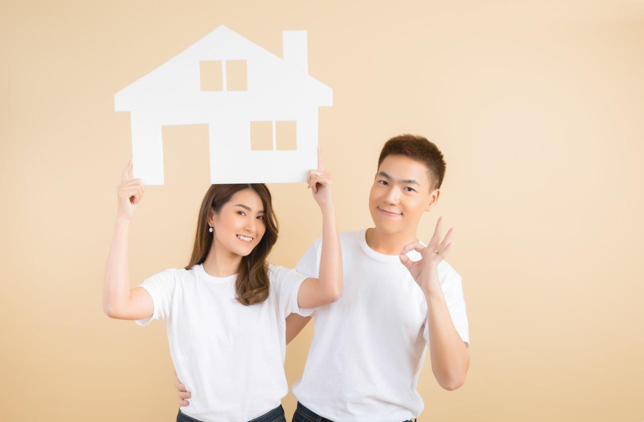 man and woman holding house cutout