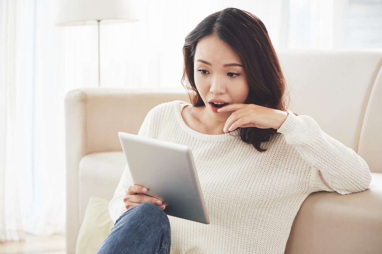 A young woman watching news at home