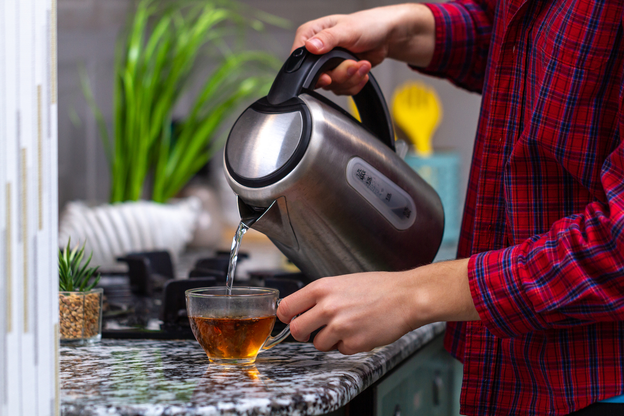 A person making tea while working from home