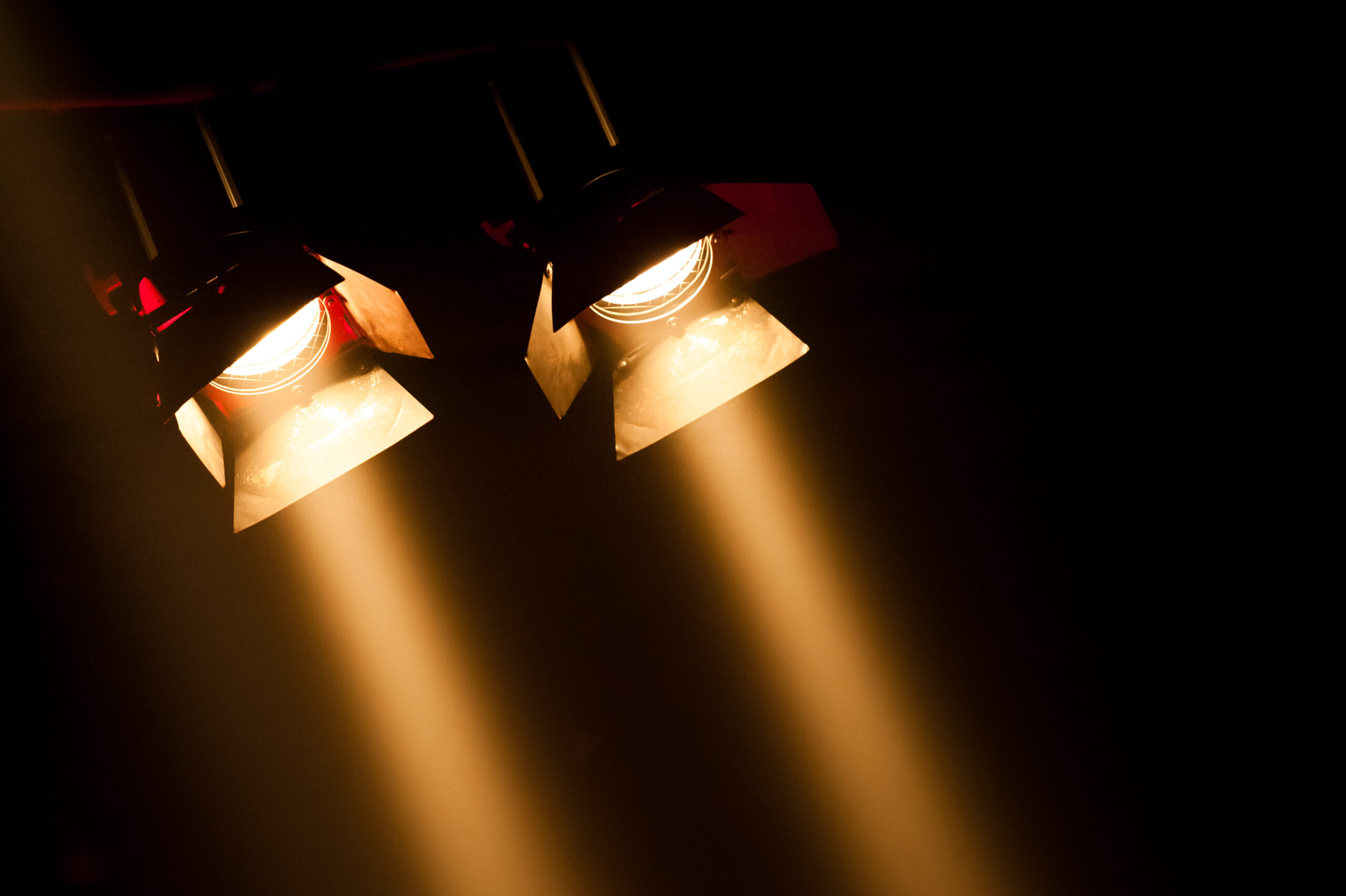 Two theatre spotlights on a black background