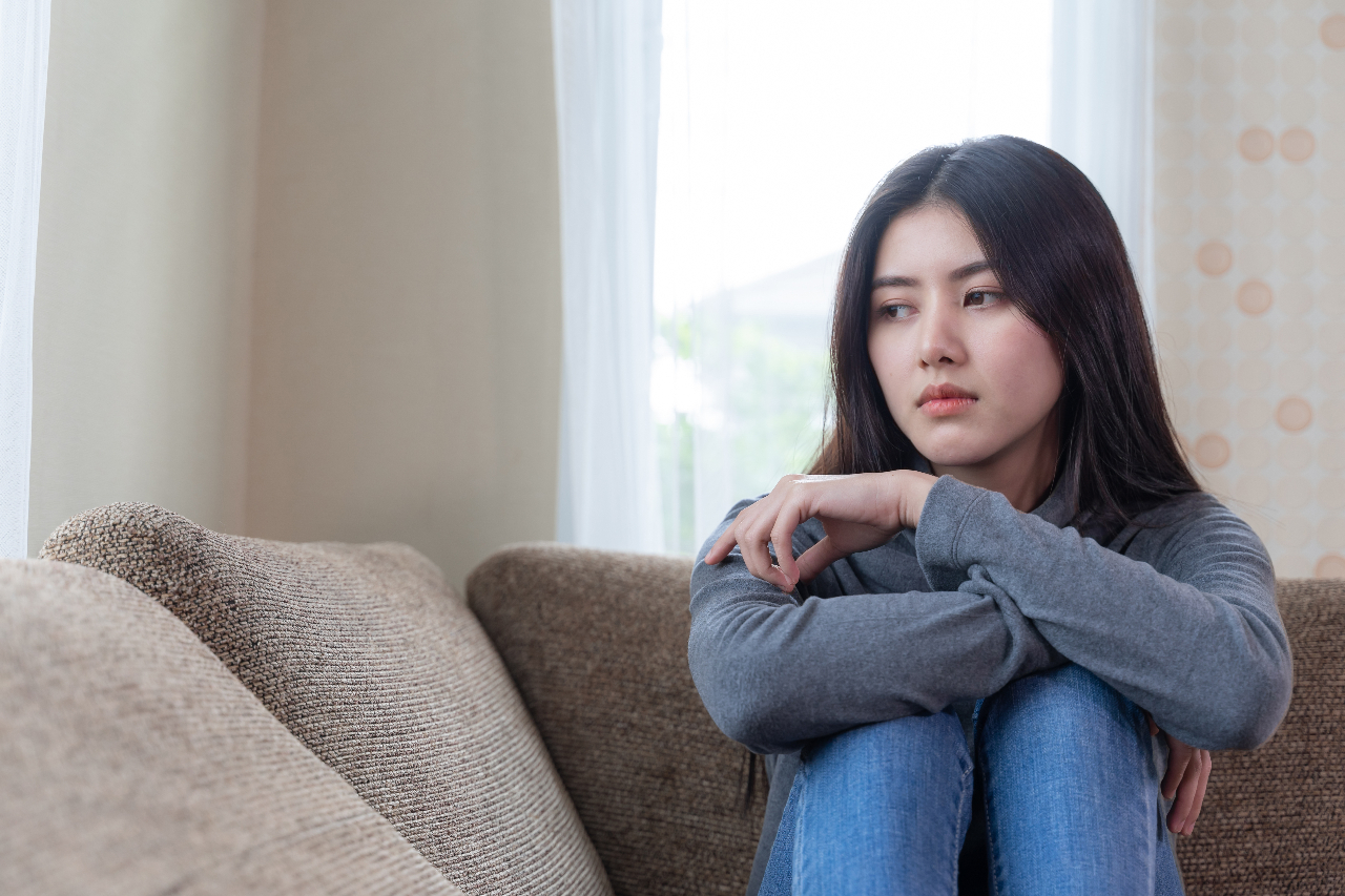 unhappy asian pretty young woman siting alone couch with feeling sadness 1